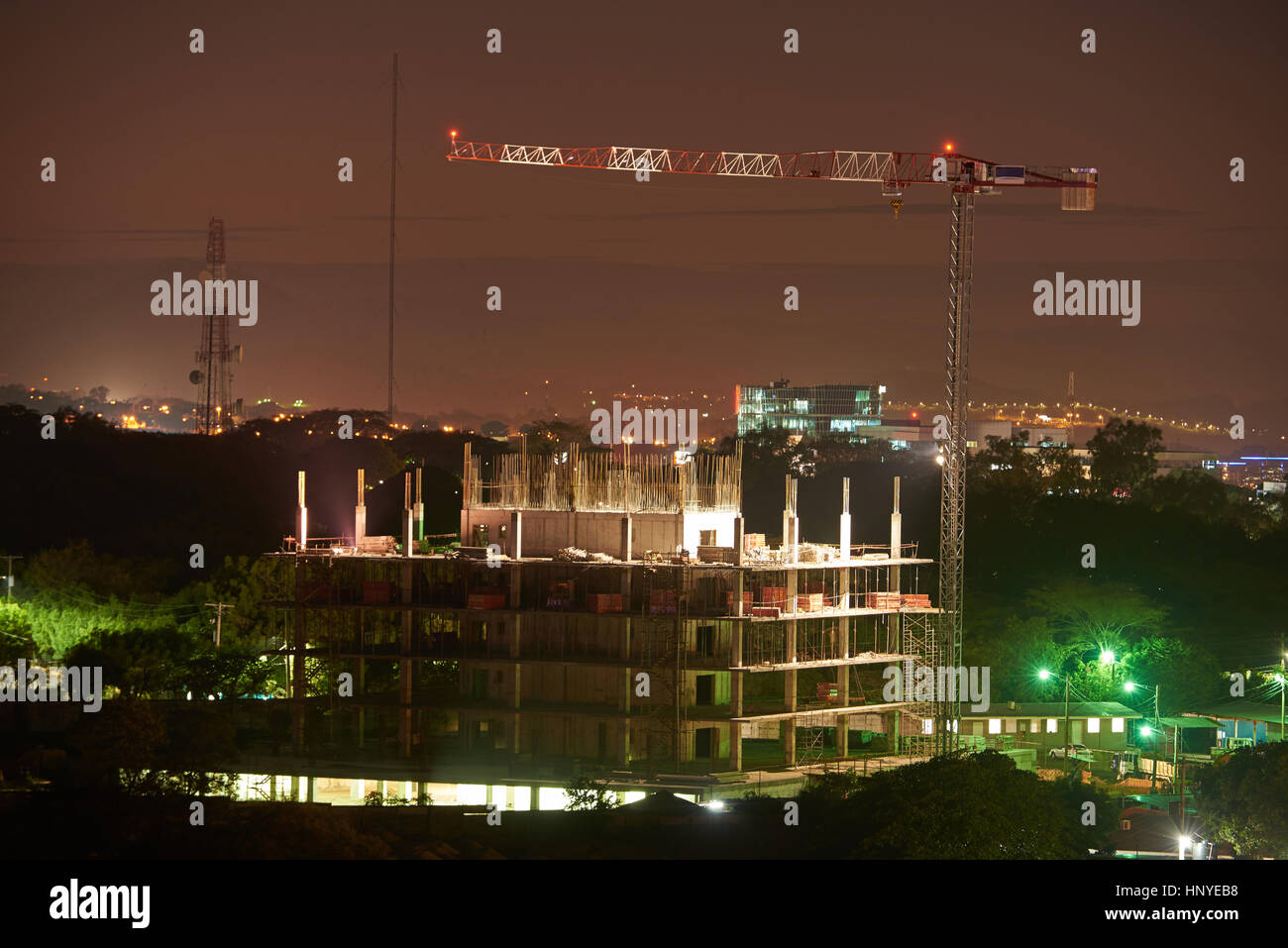 Bau Kran in der Nacht mit Gebäude im Bau Stockfoto