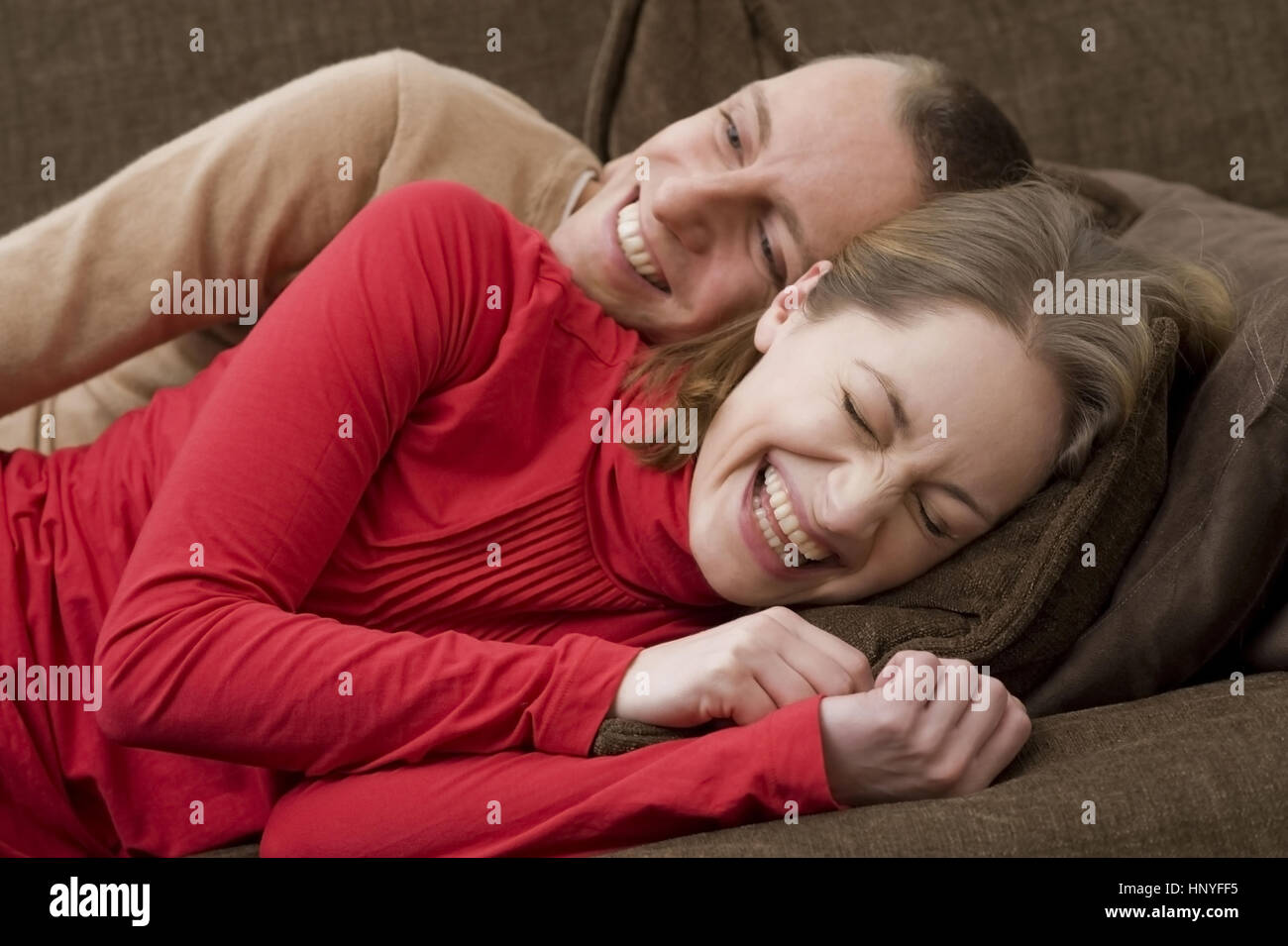 Model Release, Lachendes Liebespaar so Gemeinsam Auf der Couch - Glück liebe paar auf einer couch Stockfoto