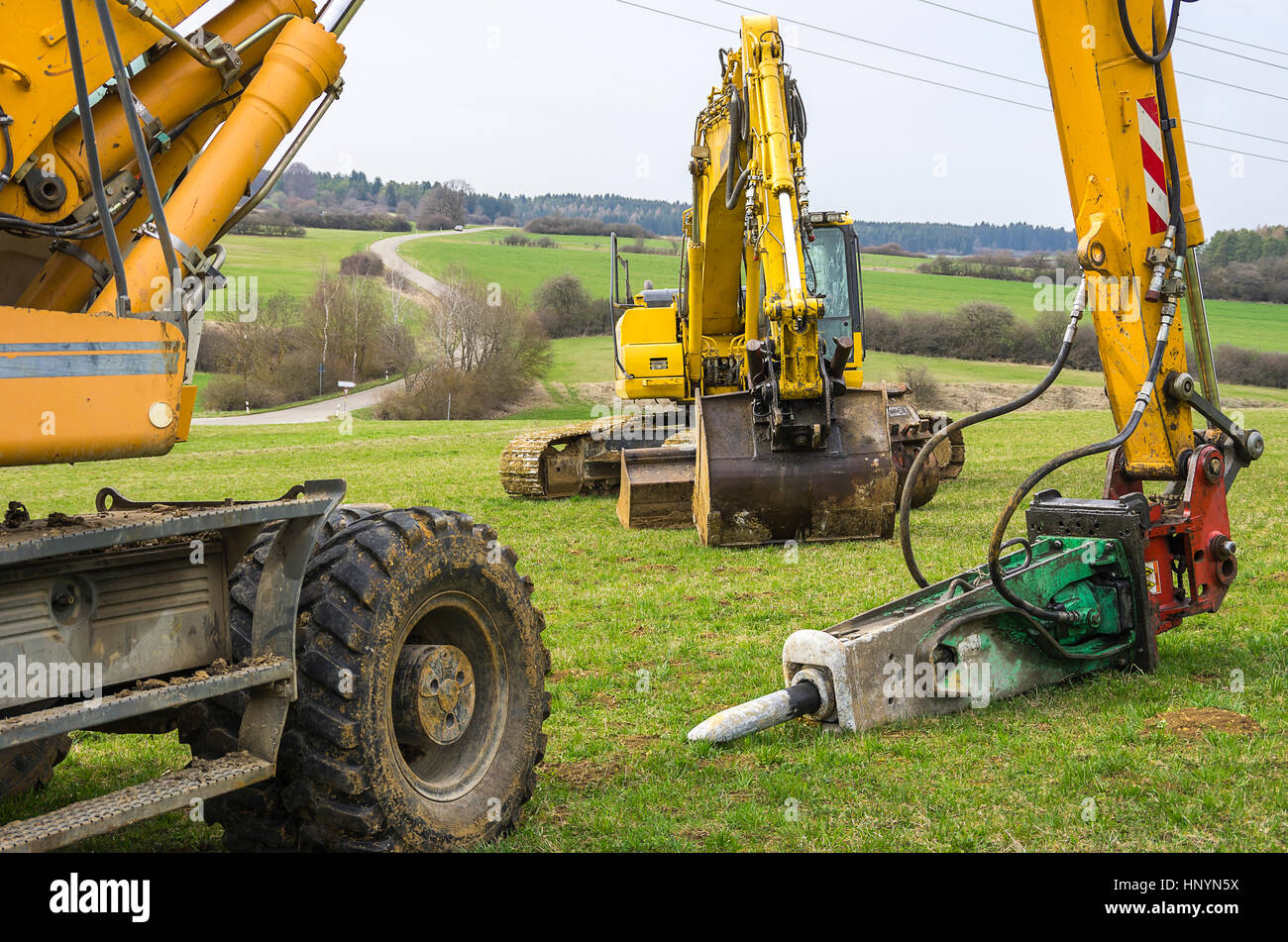 Baumaschinen wie Bagger und Presslufthämmer auf einem Grundstück für die Landschaftsgestaltung. Stockfoto