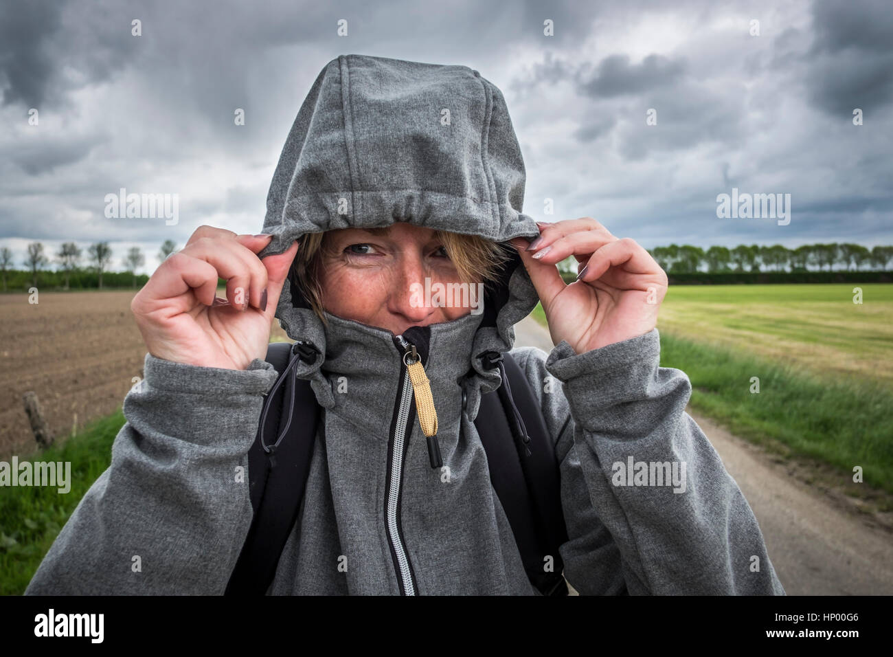 Frau setzt ihre Mütze auf die Jacke für den Sturm zu kommen Stockfoto