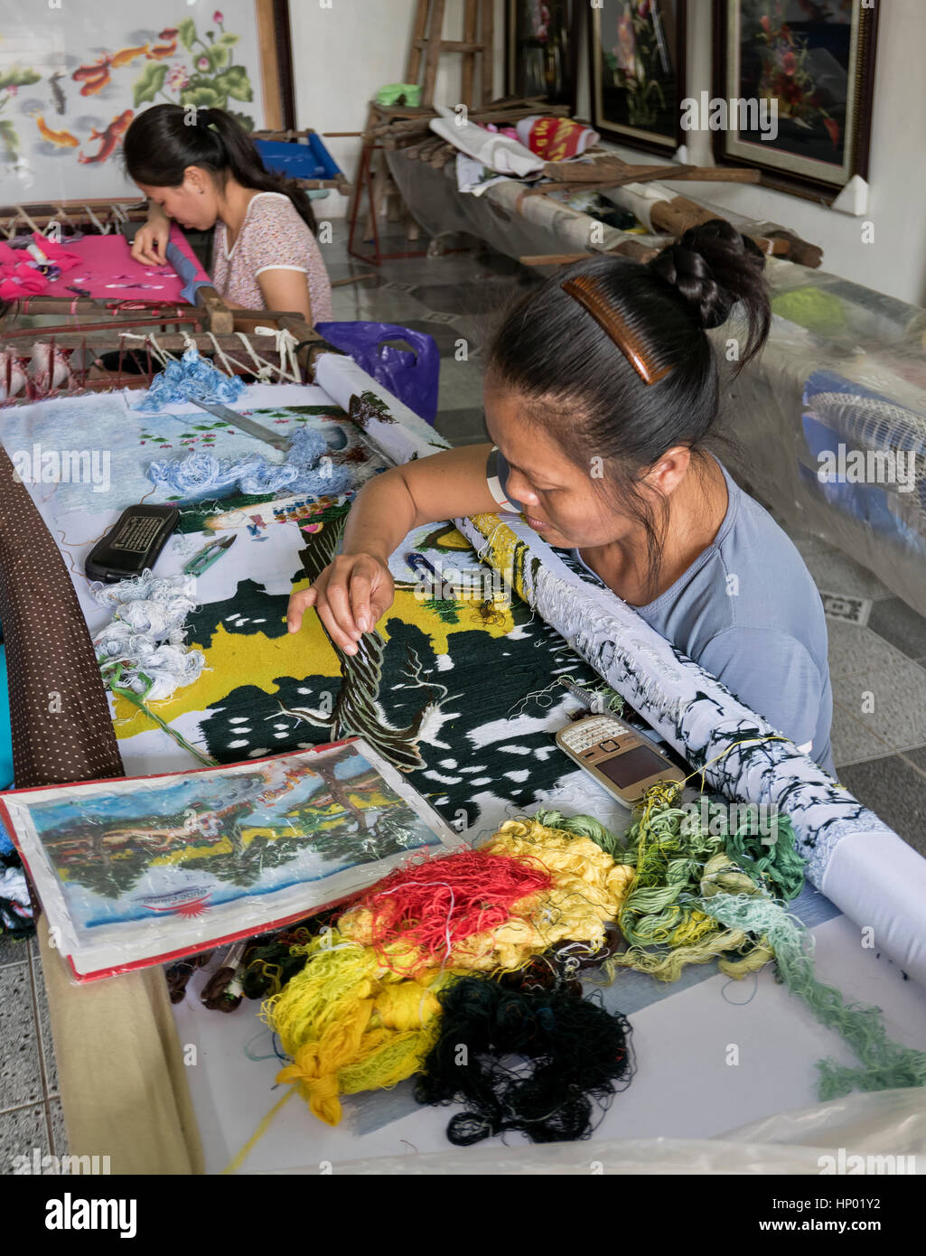 Frau Hand Sticken bunten vietnamesischen Szene, Hanoi Industrie Dorf Quat Dong. Stockfoto