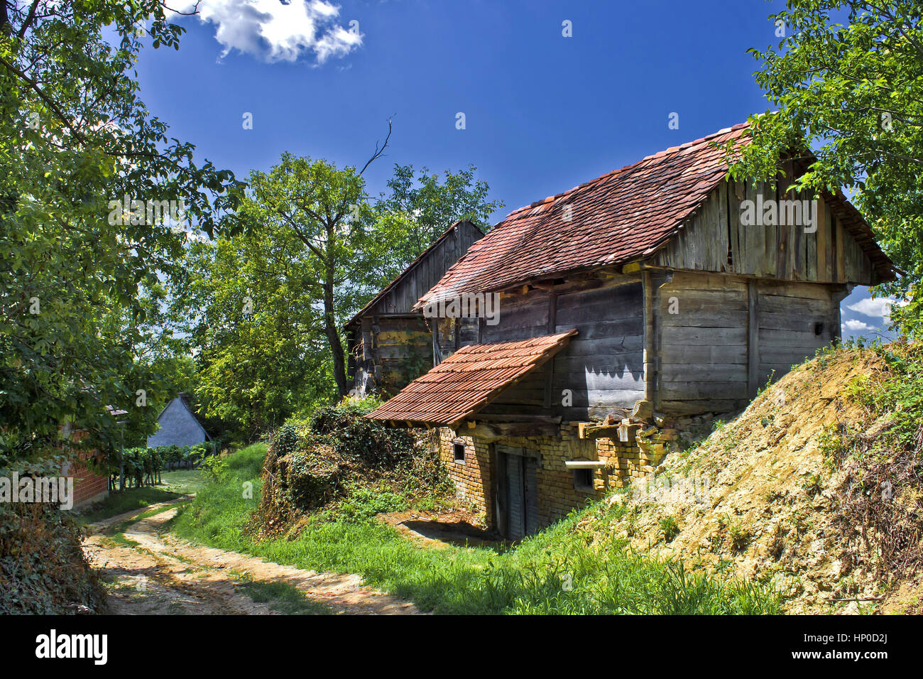 Ländliche Dorf von Zaistovec in Kroatien, mit Holzhütten - Weinkeller und unbefestigte Straße Stockfoto
