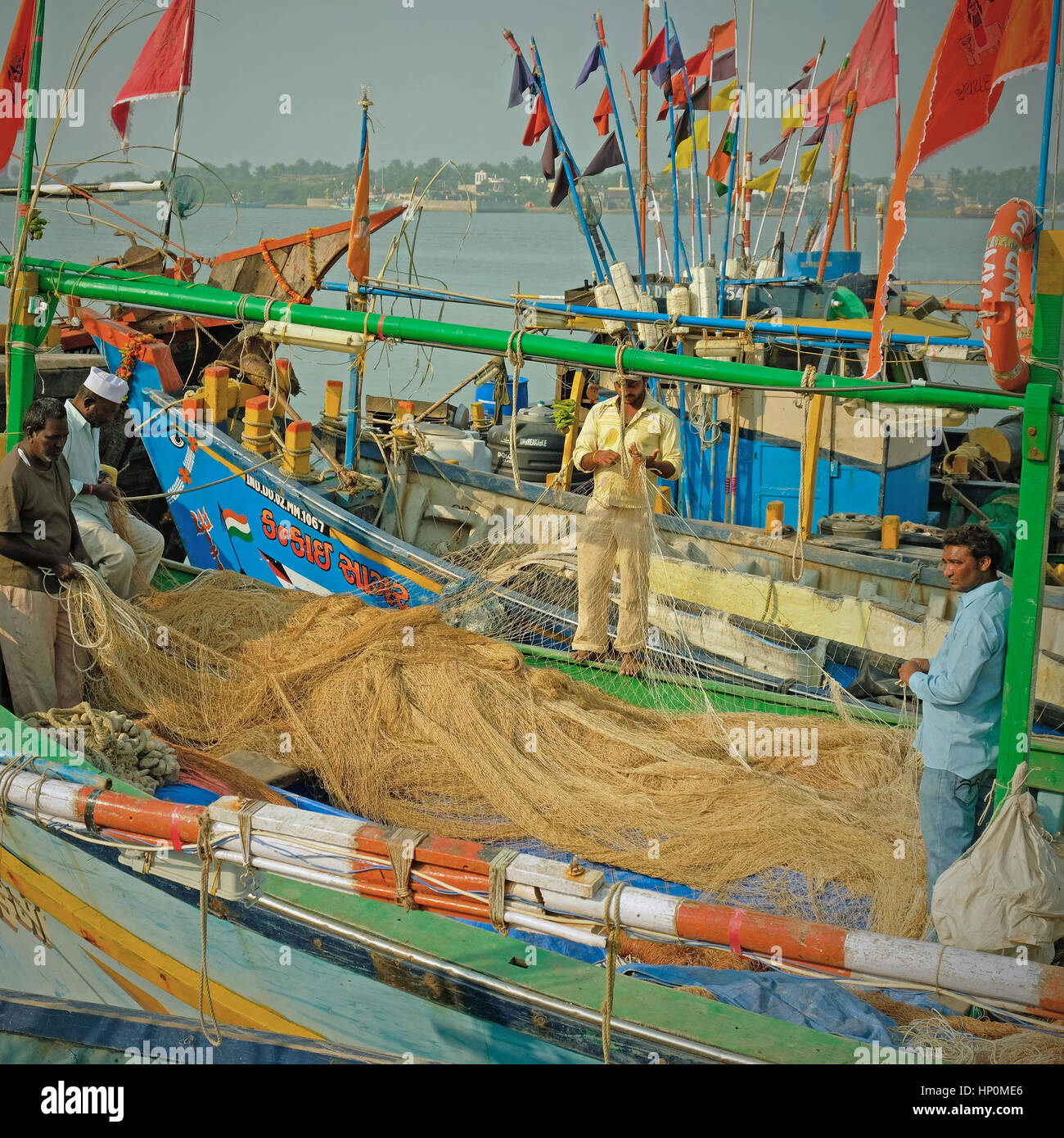 Netze für Schäden an Bord der Fischerboote im Hafen auf Diu Insel, Indien kontrolliert. Die Fischerei im arabischen Meer ist ein wichtiges Standbein der lokalen Wirtschaft Stockfoto