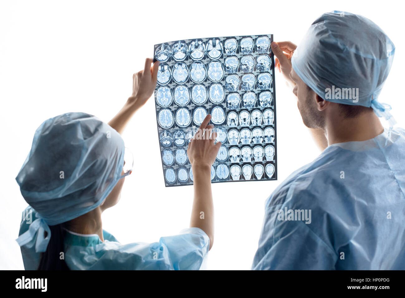 Chirurgen in medizinische Uniformen Prüfung Röntgenbild auf weiß Stockfoto