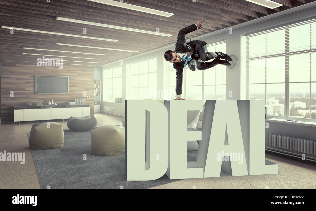 Fröhliche Jungunternehmer tanzen in seinem Büro. Mixed-media Stockfoto