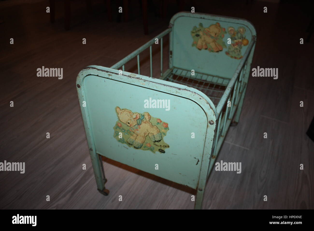 Dies ist ein Amsco der 1950er Jahre Metall Puppe Krippe mit Tropfenseite und Rädern, hellgrün und Abziehbilder Stockfoto