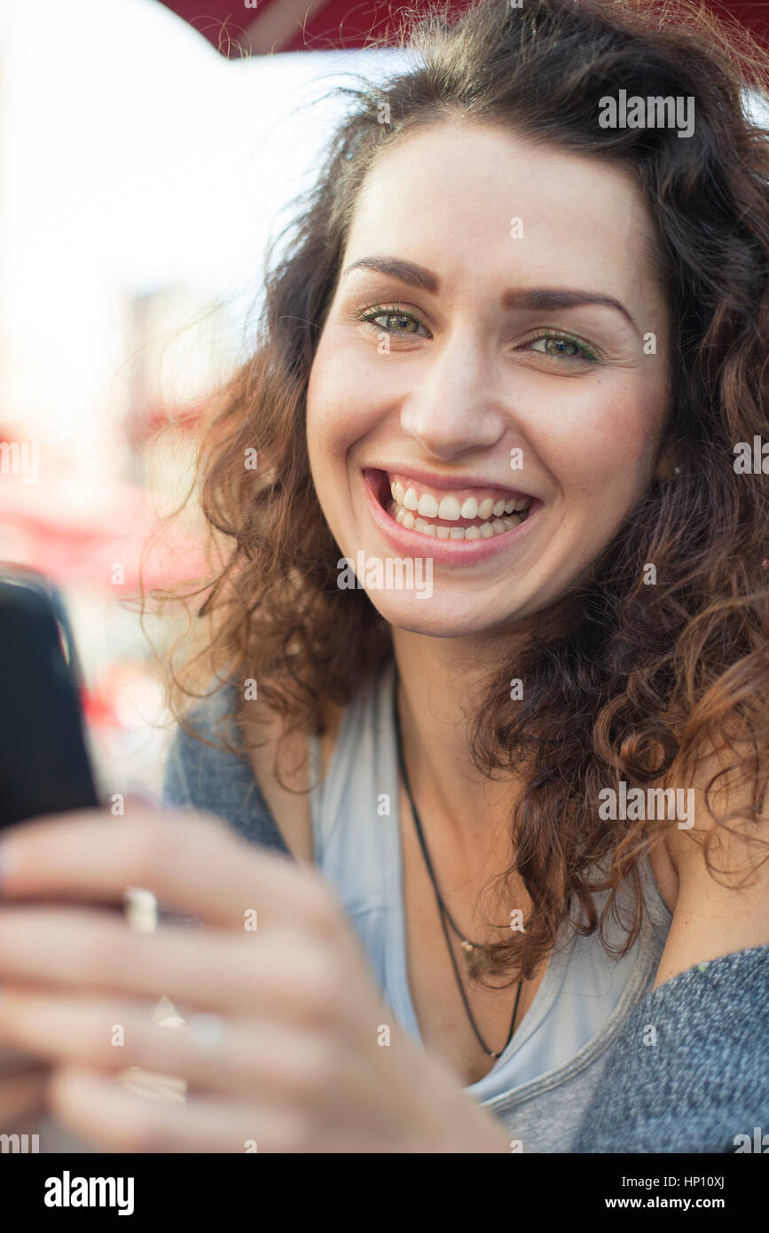 Junge Frau mit Smartphone, Lächeln, Porträt Stockfoto