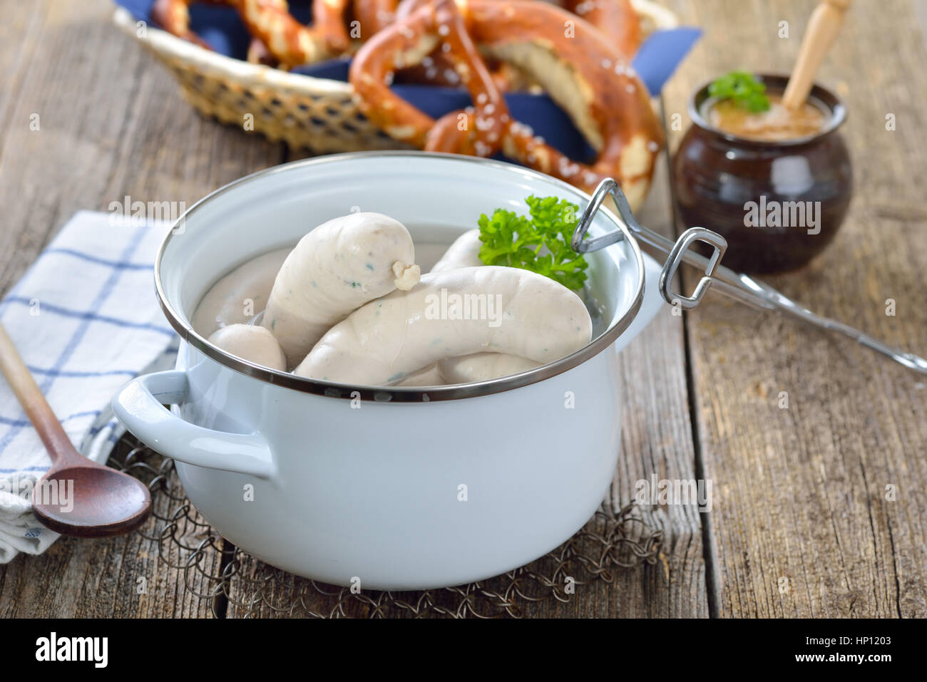 Heißen bayrische Weißwürste in einem Kochtopf Emaille auf einem Holztisch  mit frischen Brezeln und süßem Senf serviert Stockfotografie - Alamy