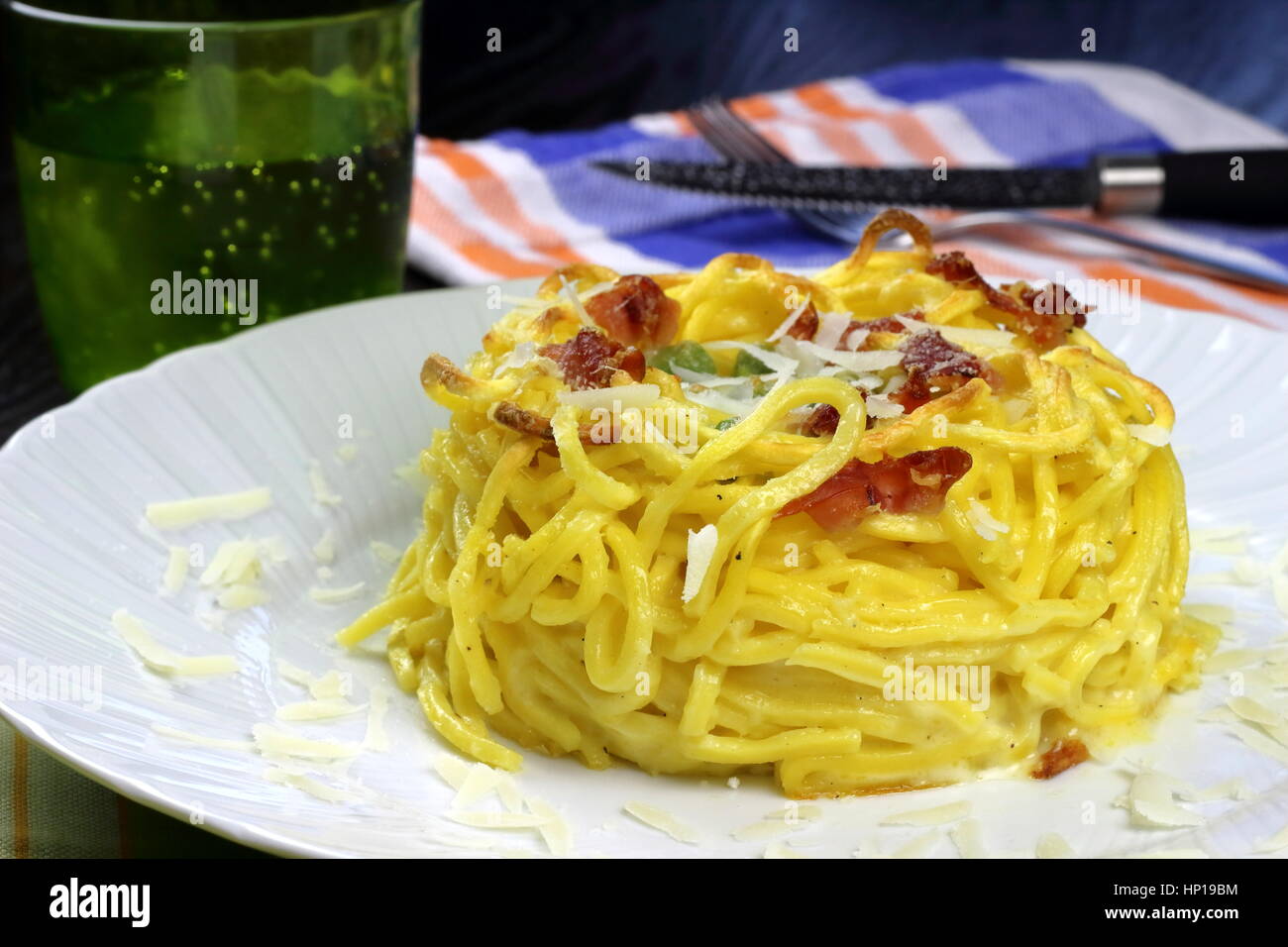 Gebackener Taleggio-Käse, Speck (auch Speck oder Kissen) und Erbsen frische Tagliolini Pasta in weißen Schale auf bunte Küchentücher - italienische Küche-Rezept Stockfoto