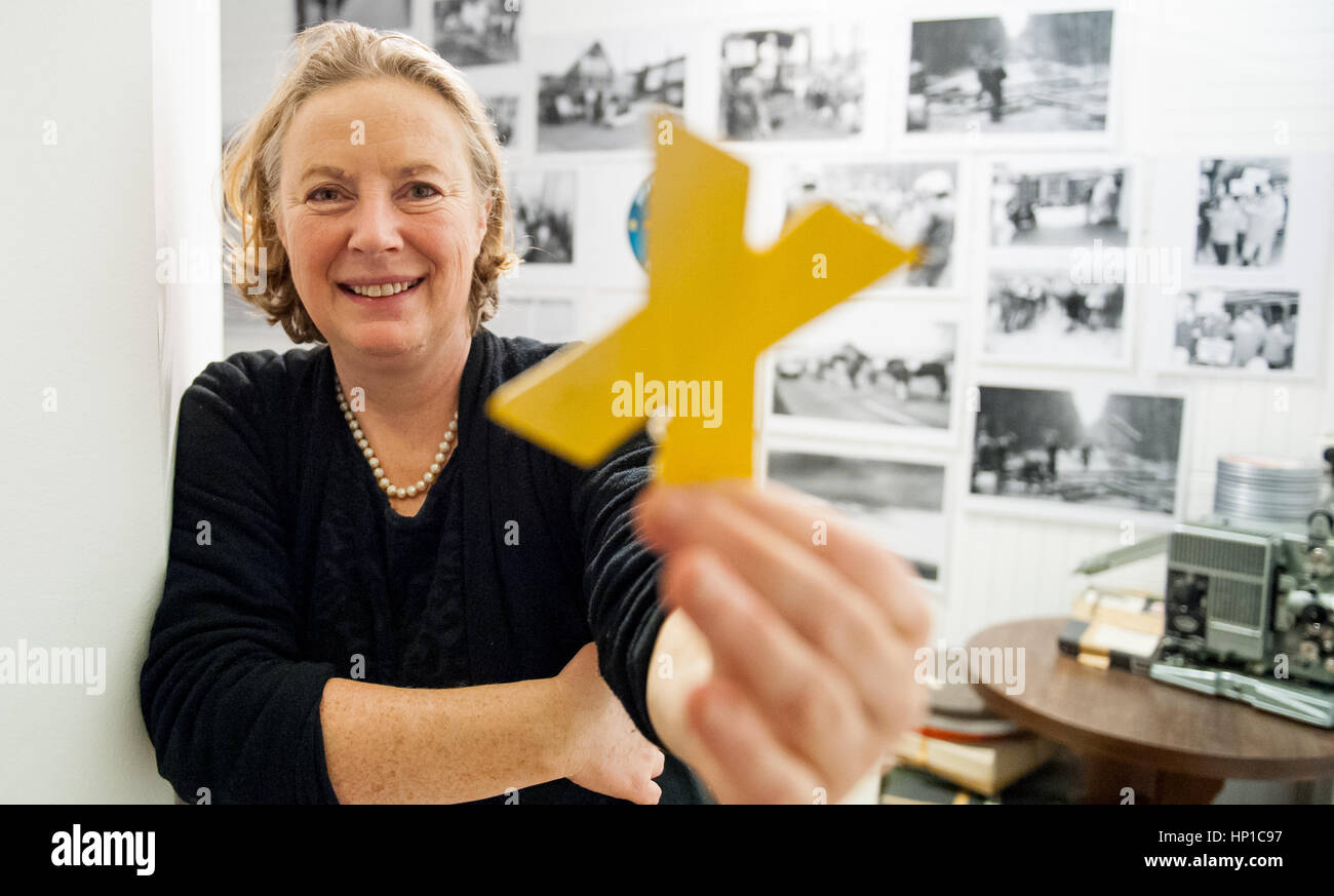 Luechow, Deutschland. 13. Februar 2017. Archiv-Direktor Birgit Huneke hält ein gelbes Kreuz, das Symbol der Anti-Atom-Aktivisten aus den 1980er Jahren in den Gorleben-Archives in Luechow, Deutschland, 13. Februar 2017. Anti-atomare-Aktivisten errichtet, ein kleines Dorf von Hütten und verkündet eine eigene Republik im Jahr 1980. Obwohl dies nicht allzu langer Zeit geschehen ist, sind die Reste bereits Interes Archäologie. Foto: Philipp Schulze/Dpa/Alamy Live News Stockfoto