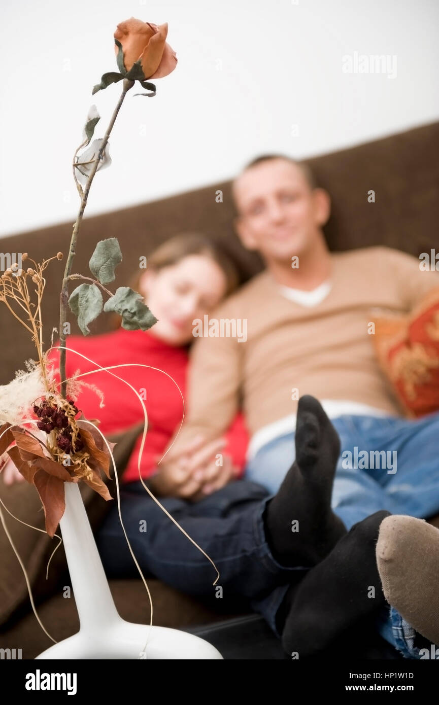 Model Release, Liebespaar Sitzt Gemeinsam Auf der Couch - Liebespaar sitzt auf einer Couch zu Hause Stockfoto