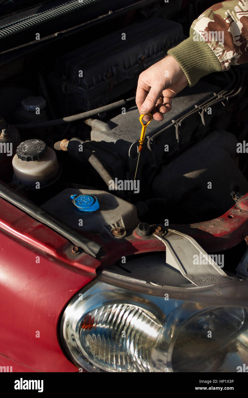 Die Mechaniker prüft die Ebene Ölmessstab Motor Stockfoto