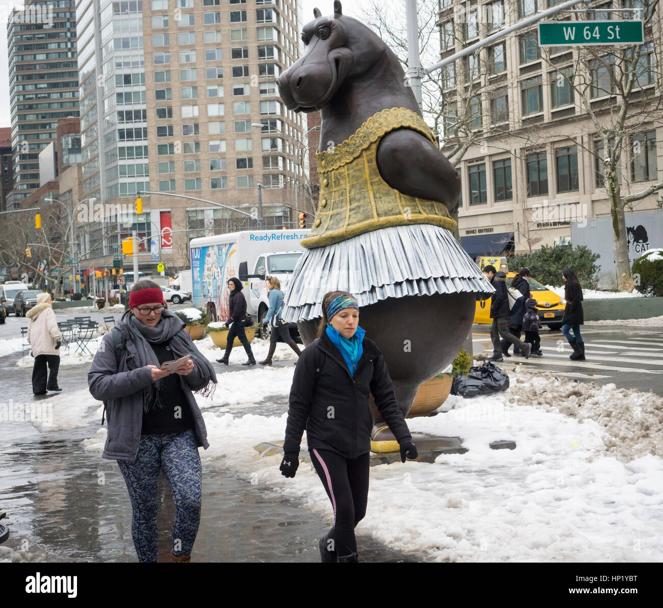 Passant Freude in die neu installierte 'Hippo Ballerina' Skulptur vom dänischen Künstler Bjørn Okholm Skaarup in Dante Park gegenüber dem Lincoln Center in New York am Samstag, 11. Februar 2017. Die 2 und eine halbe Tonne über 15 Fuß hohen Bronzeskulptur der tanzende Nilpferde in Disneys "Fantasia" Film und von Degas' Ballerina Gemälde inspiriert. Die beliebte Skulptur werden durch 31. Juli 2017. (© Richard B. Levine) Stockfoto