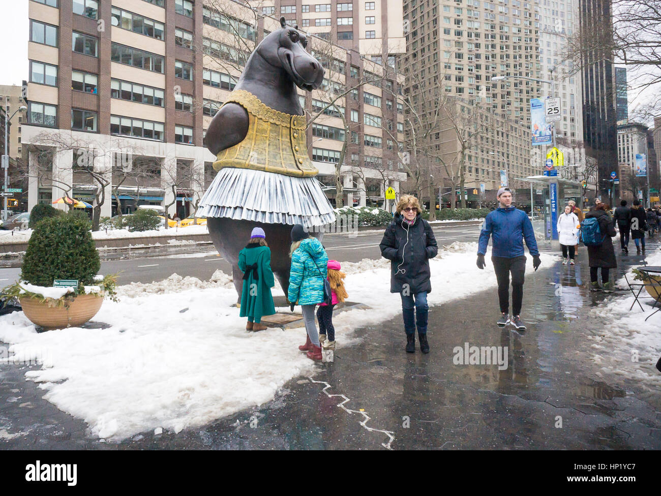 Passant Freude in die neu installierte 'Hippo Ballerina' Skulptur vom dänischen Künstler Bjørn Okholm Skaarup in Dante Park gegenüber dem Lincoln Center in New York am Samstag, 11. Februar 2017. Die 2 und eine halbe Tonne über 15 Fuß hohen Bronzeskulptur der tanzende Nilpferde in Disneys "Fantasia" Film und von Degas' Ballerina Gemälde inspiriert. Die beliebte Skulptur werden durch 31. Juli 2017. (© Richard B. Levine) Stockfoto
