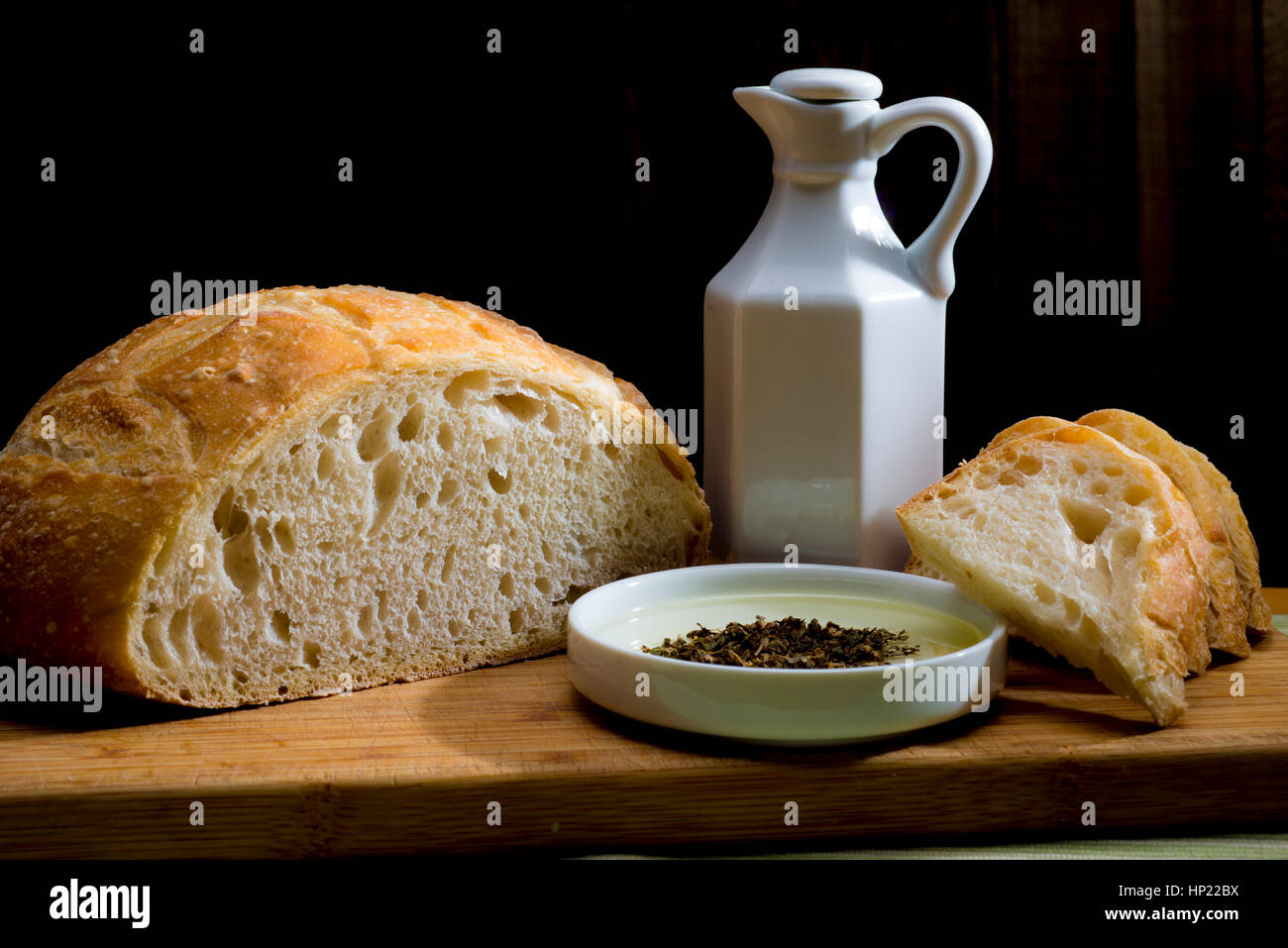 rundes Laib Brot schneiden mit Ölen Stockfoto