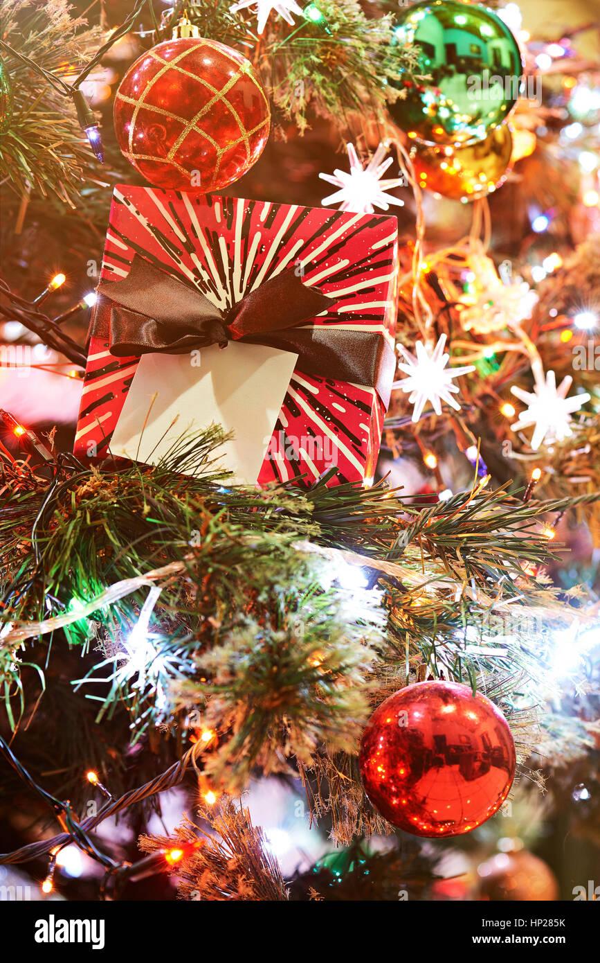 Weihnachtsdekoration auf Baum mit Lichter und hängenden Kugeln Stockfoto