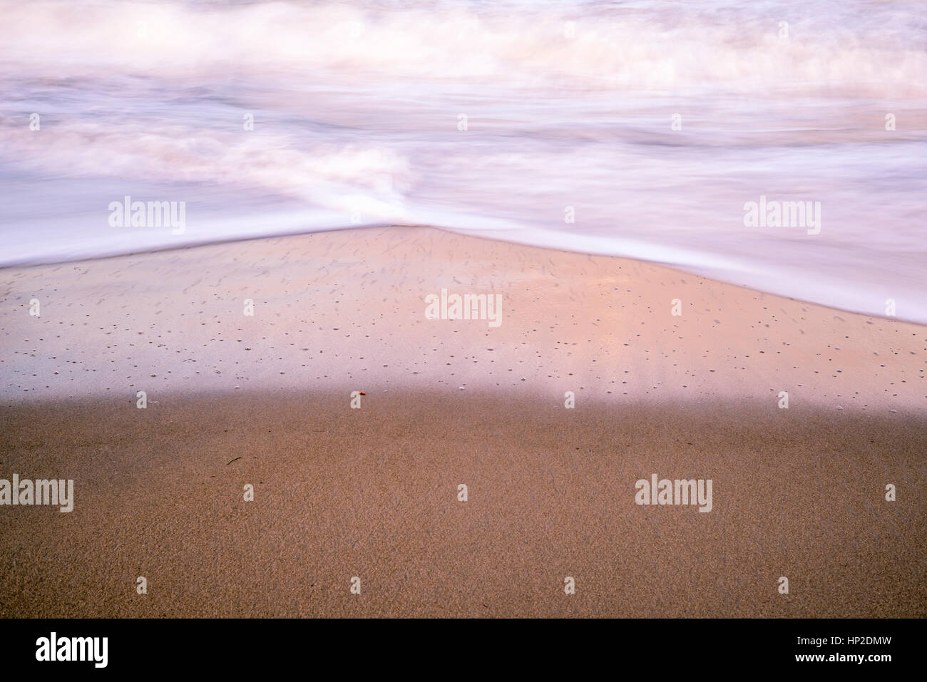 Nahaufnahme von Strand, Sand und Wellen. Langzeitbelichtung Bild. Stockfoto