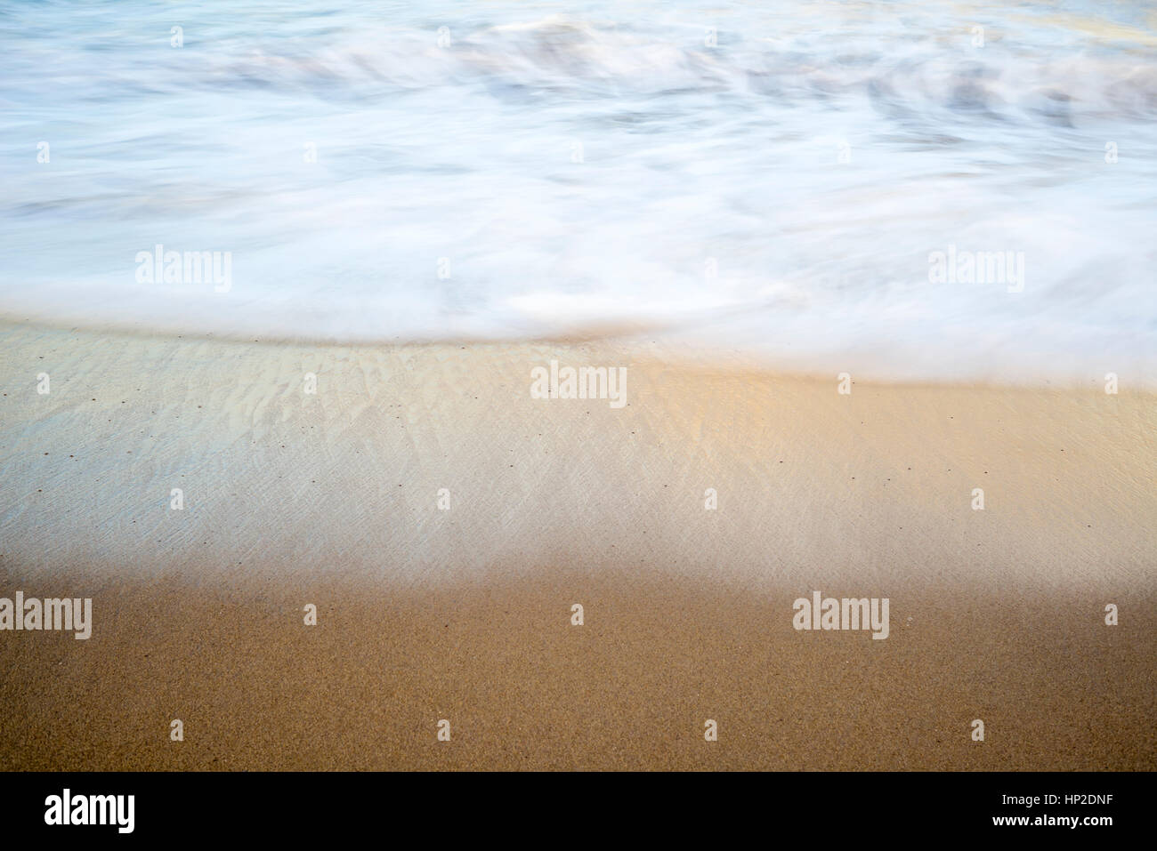 Nahaufnahme von Strand, Sand und Wellen. Langzeitbelichtung Bild. Stockfoto