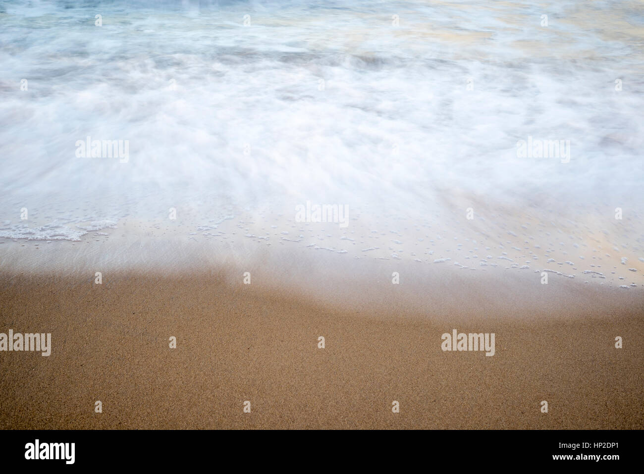 Nahaufnahme von Strand, Sand und Wellen. Langzeitbelichtung Bild. Stockfoto