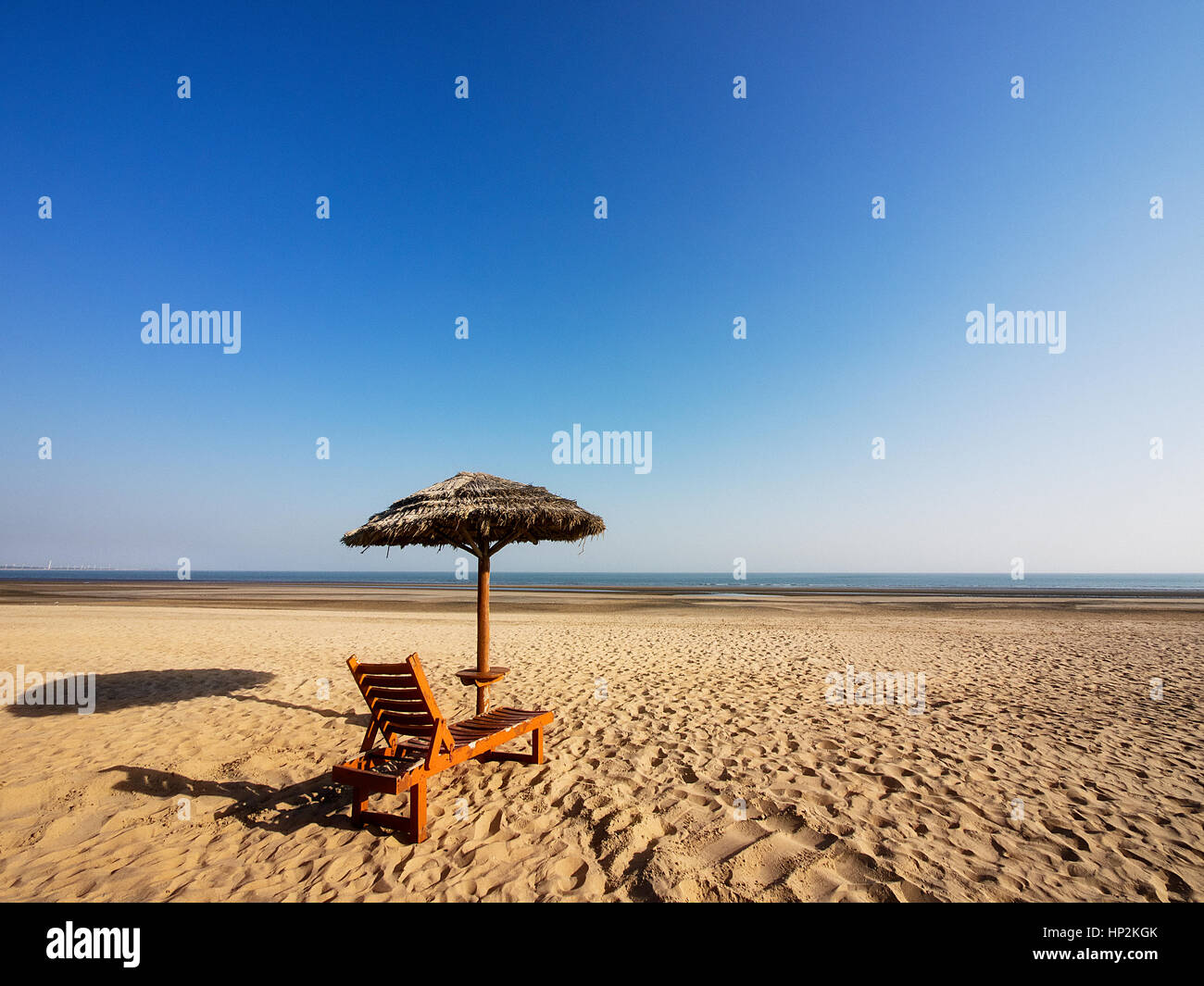Sonnenschirm und Stuhl, Weitwinkel, Sand, klarer Himmel, Arabisches Meer, Indien Stockfoto