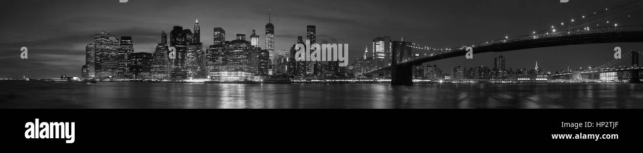 New York City mit Brooklyn Bridge, legendären Skyline Panorama nachts in schwarz / weiß Stockfoto