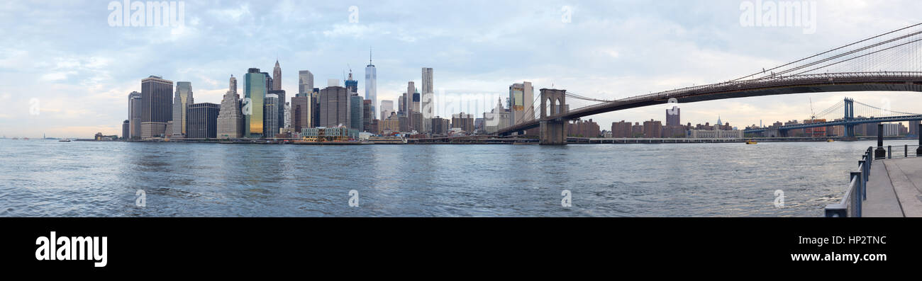Skyline von New York und Brooklyn Bridge in blau bewölktem Stockfoto