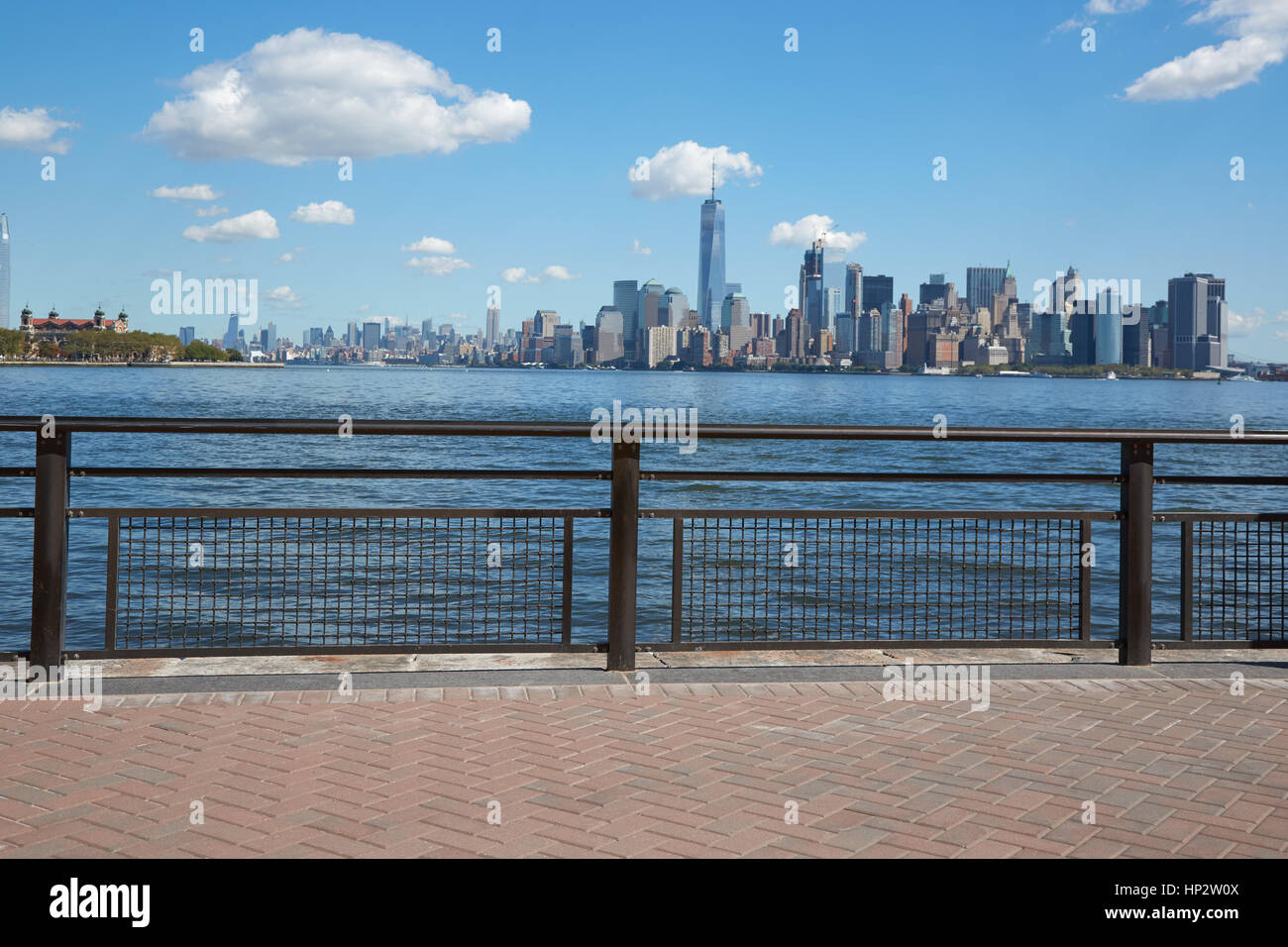 New York City Skyline Blick und Ellis Island vom leeren Dock Terrasse im Sommer, blauer Himmel Stockfoto