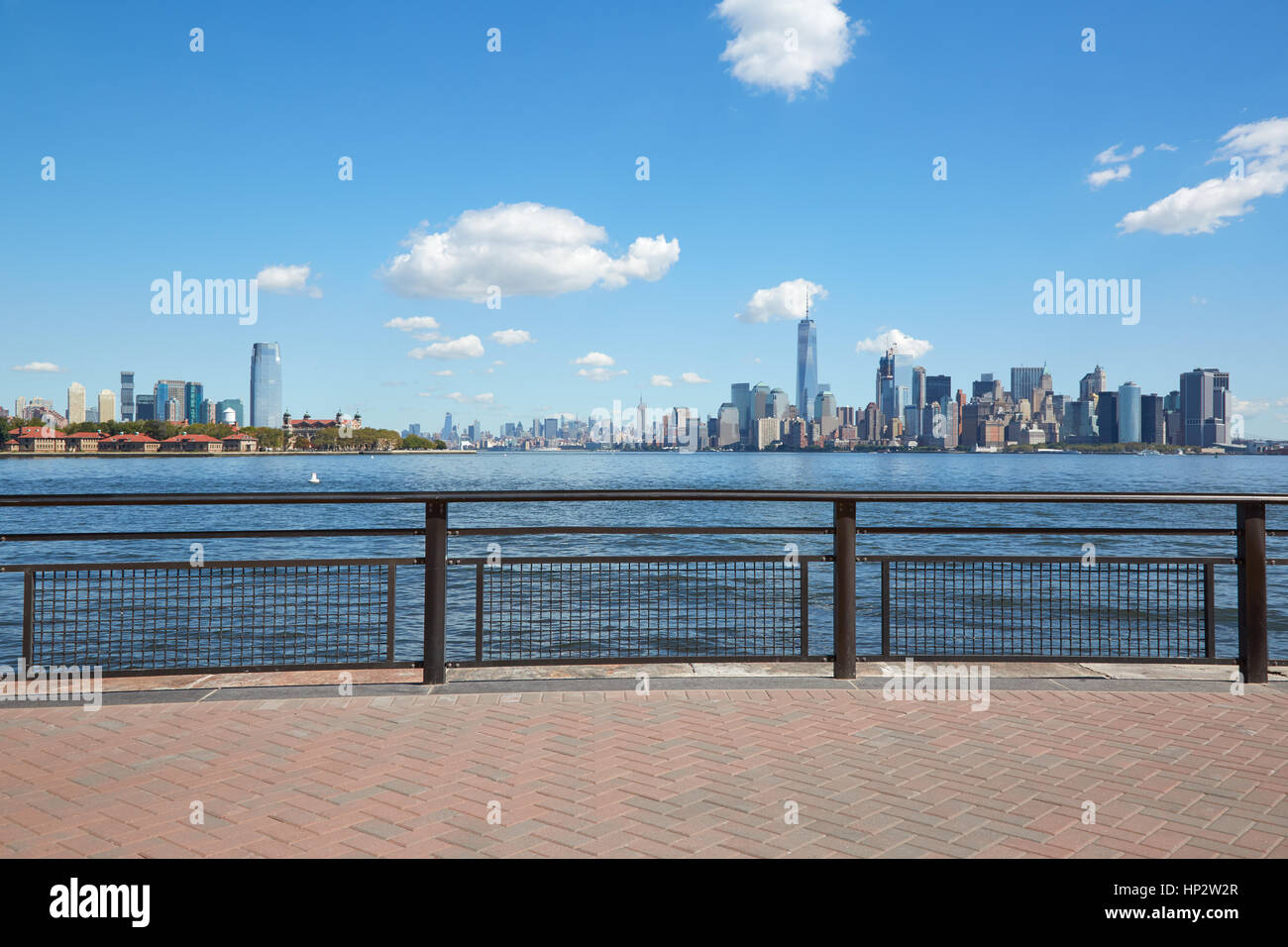 Skyline von New York und Ellis Island Blick von leeren Dock Terrasse an einem sonnigen Tag Stockfoto
