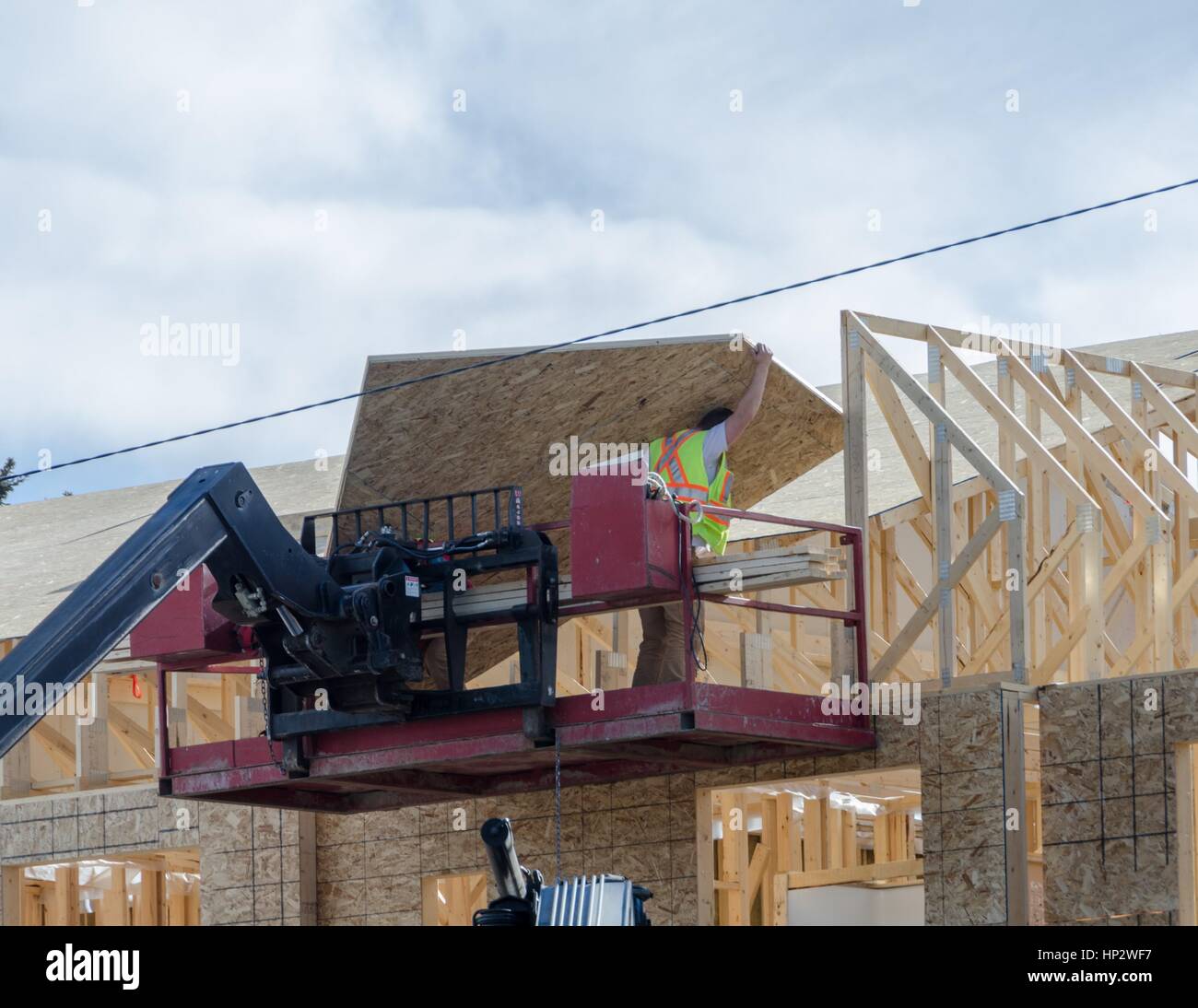 Bauarbeiter laden Materialien an einem Wohnhaus-Standort in Calgary, Alberta, Kanada. Stockfoto