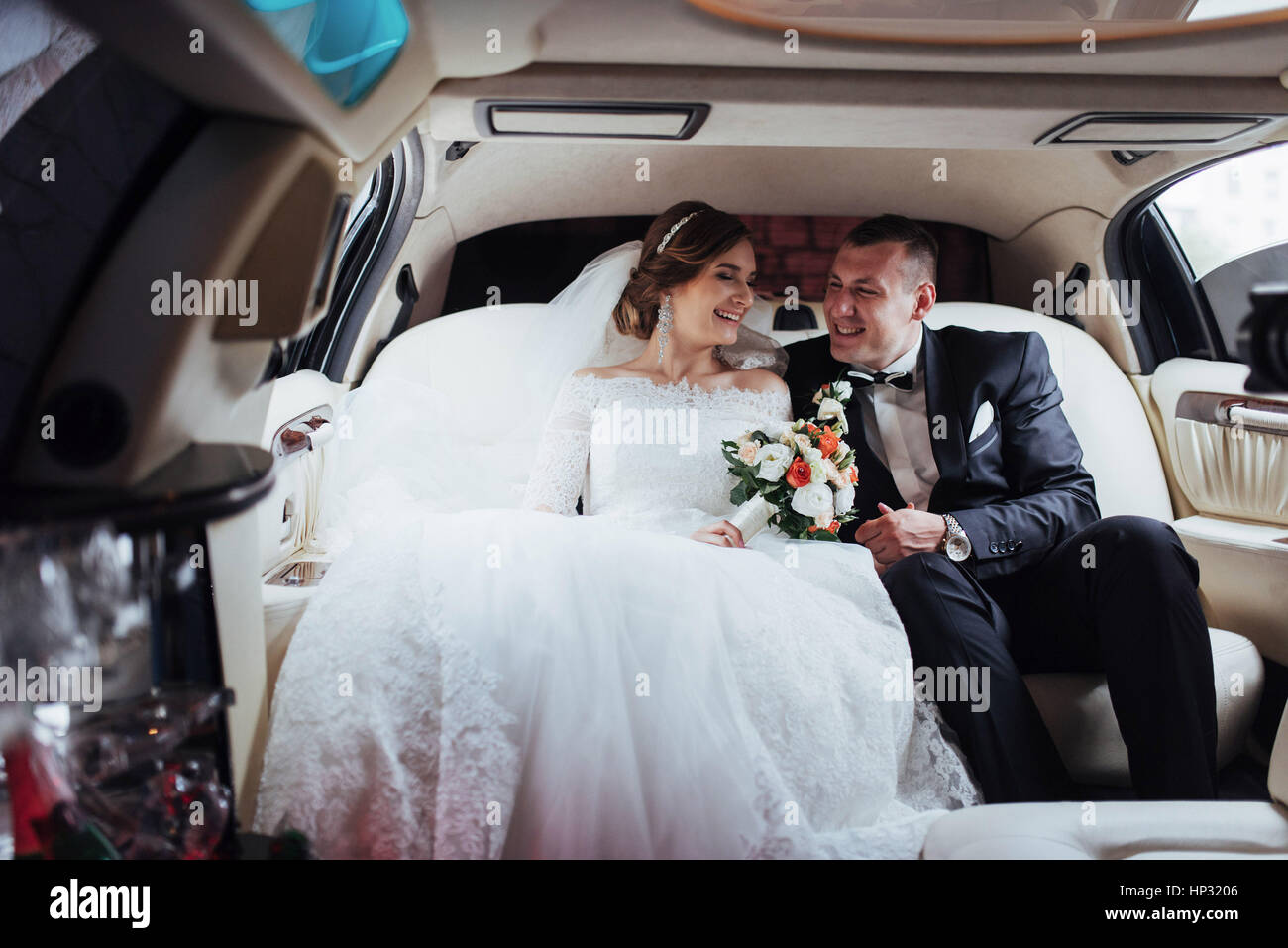 junges Paar in einem Auto in Hochzeitstag. Stockfoto