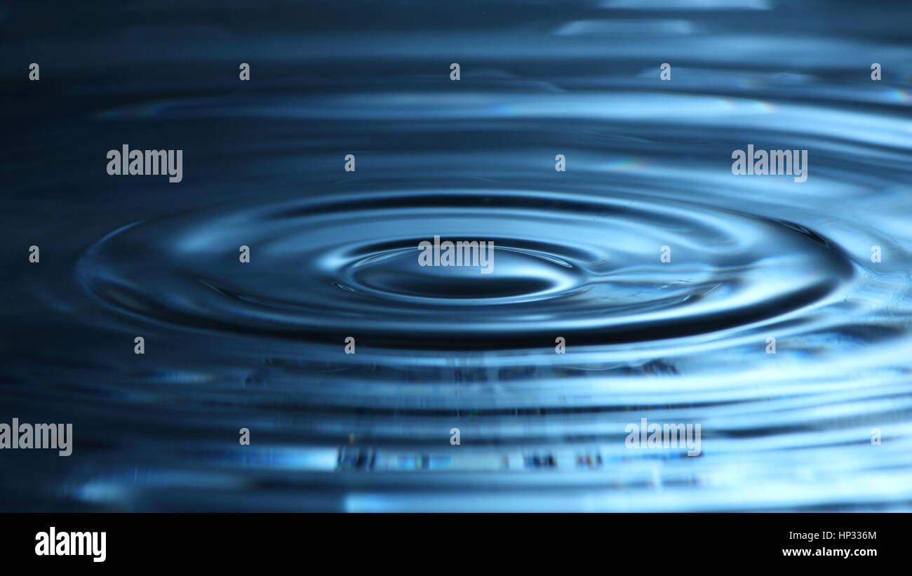 Domino-Effekt: Wasser Tropfen Fotografie mit Wellen auf der Oberfläche und blaue Reflexion Stockfoto
