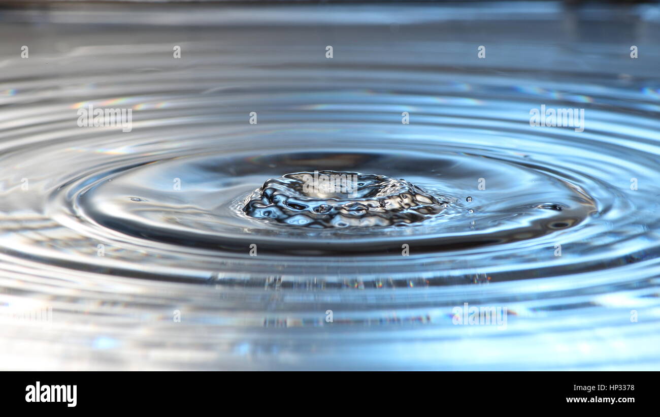 Flüssiges Metall: Wasser Tropfen Fotografie zeigt eine Welle mit schwebenden Tropfen über der Oberfläche. Stockfoto