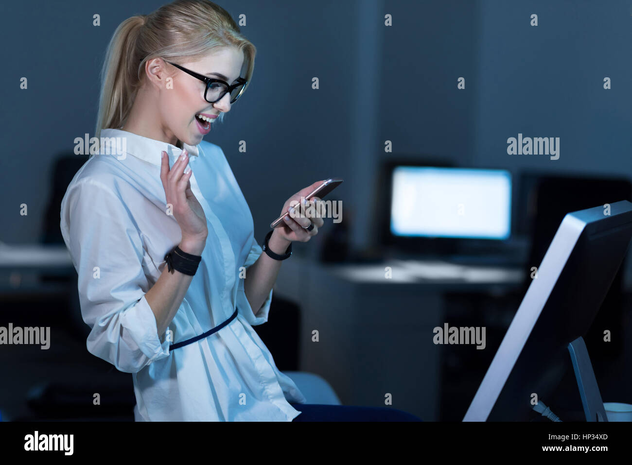 Lebhafte junge Geschäftsfrau, die positive Emotionen im Büro Stockfoto