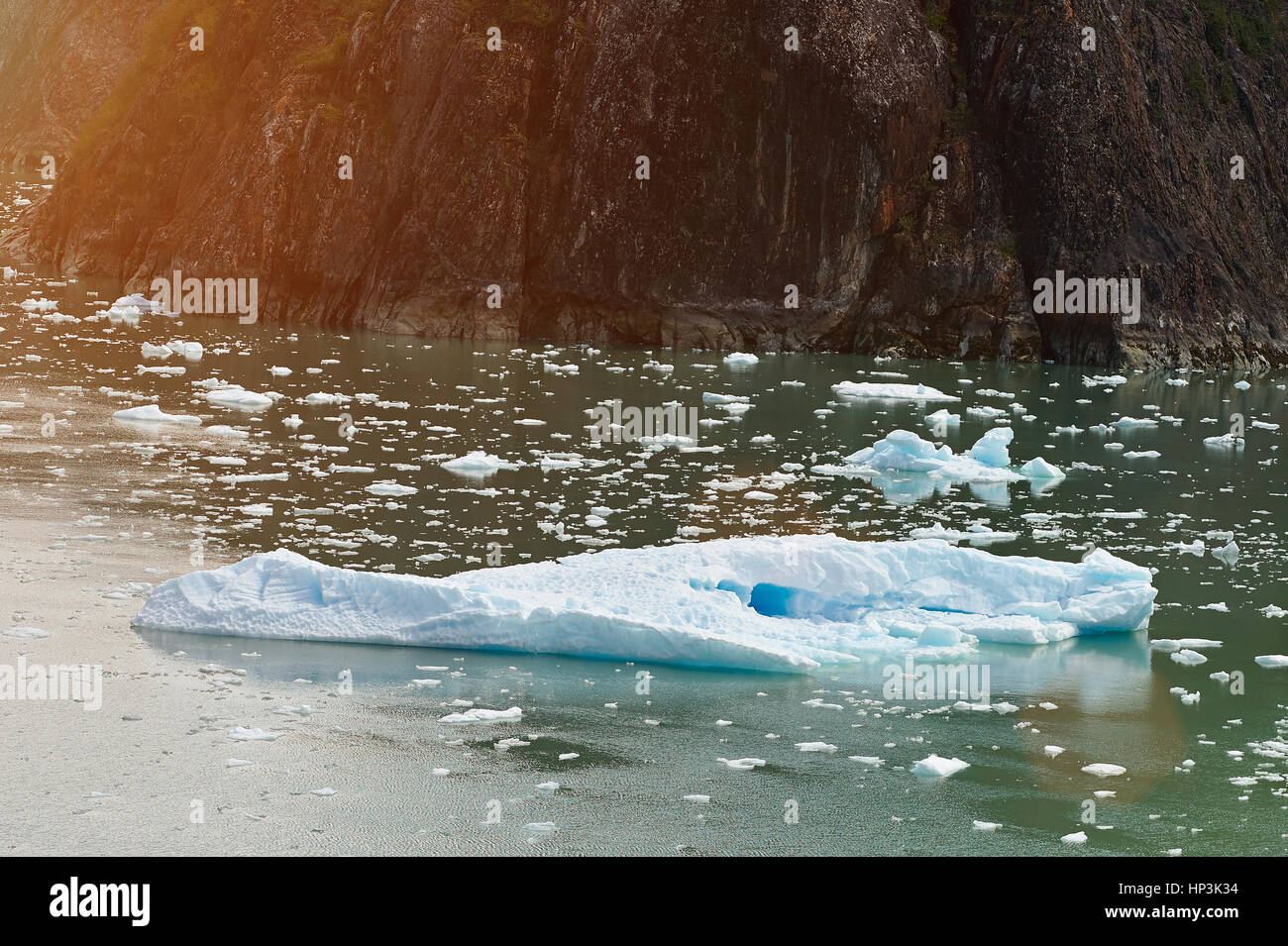Ein großer Eisberg schweben neben großen Felsen. Alaska-Bootstour in Gletscher Stockfoto