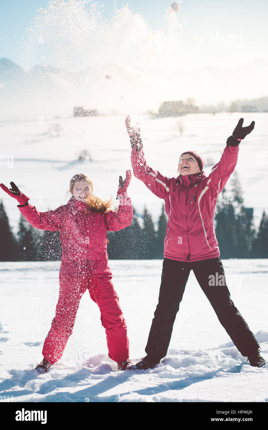 Mutter genießen den Schnee mit ihrer Tochter im Freien im Winter Stockfoto