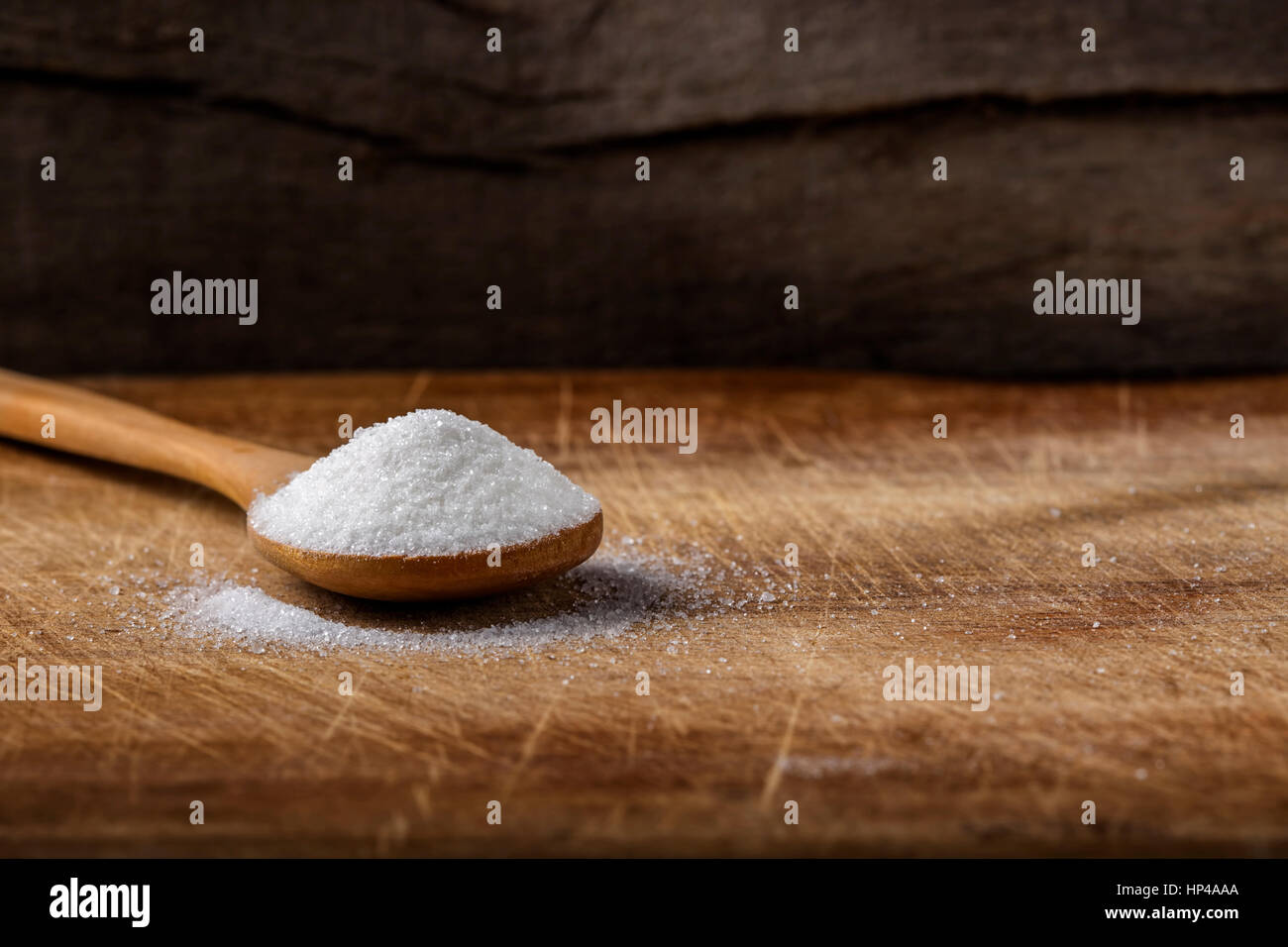 Ein Bambuslöffel gefüllt mit weißem Zucker über hölzerne Hintergrund mit Textfreiraum Stockfoto