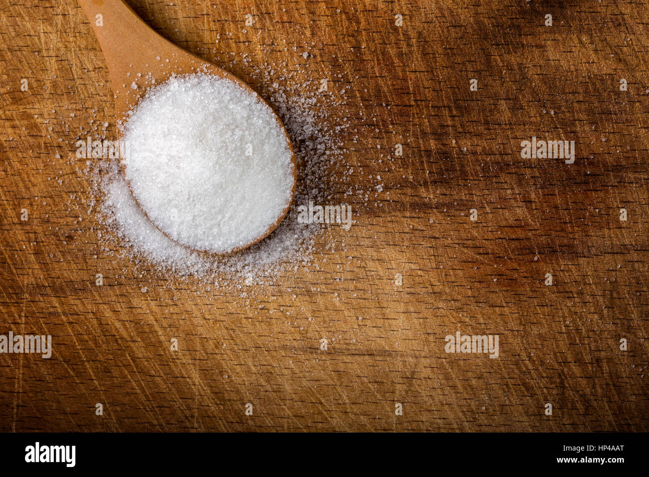 Ein Bambuslöffel gefüllt mit weißem Zucker über hölzerne Hintergrund mit Textfreiraum Stockfoto