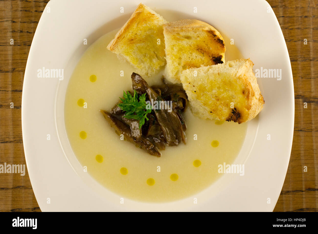 Blumenkohl-Suppe mit Pilzen und Öltropfen Stockfoto