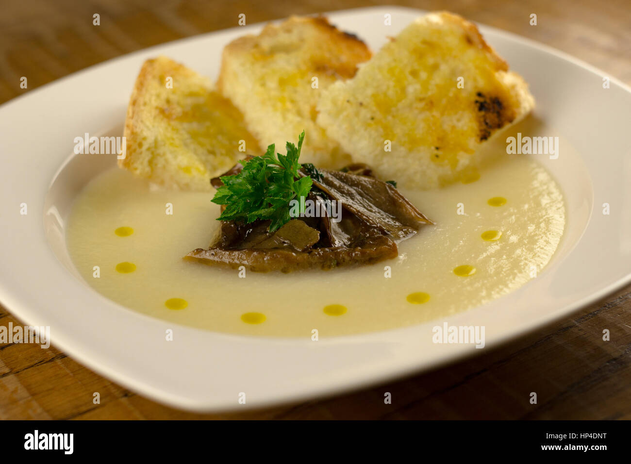Blumenkohl-Suppe mit Pilzen und Öltropfen Stockfoto