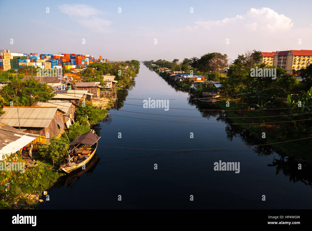 Ein Kanal mit Gehäusen und Industriegebiet in Nord-Jakarta, Indonesien. Stockfoto