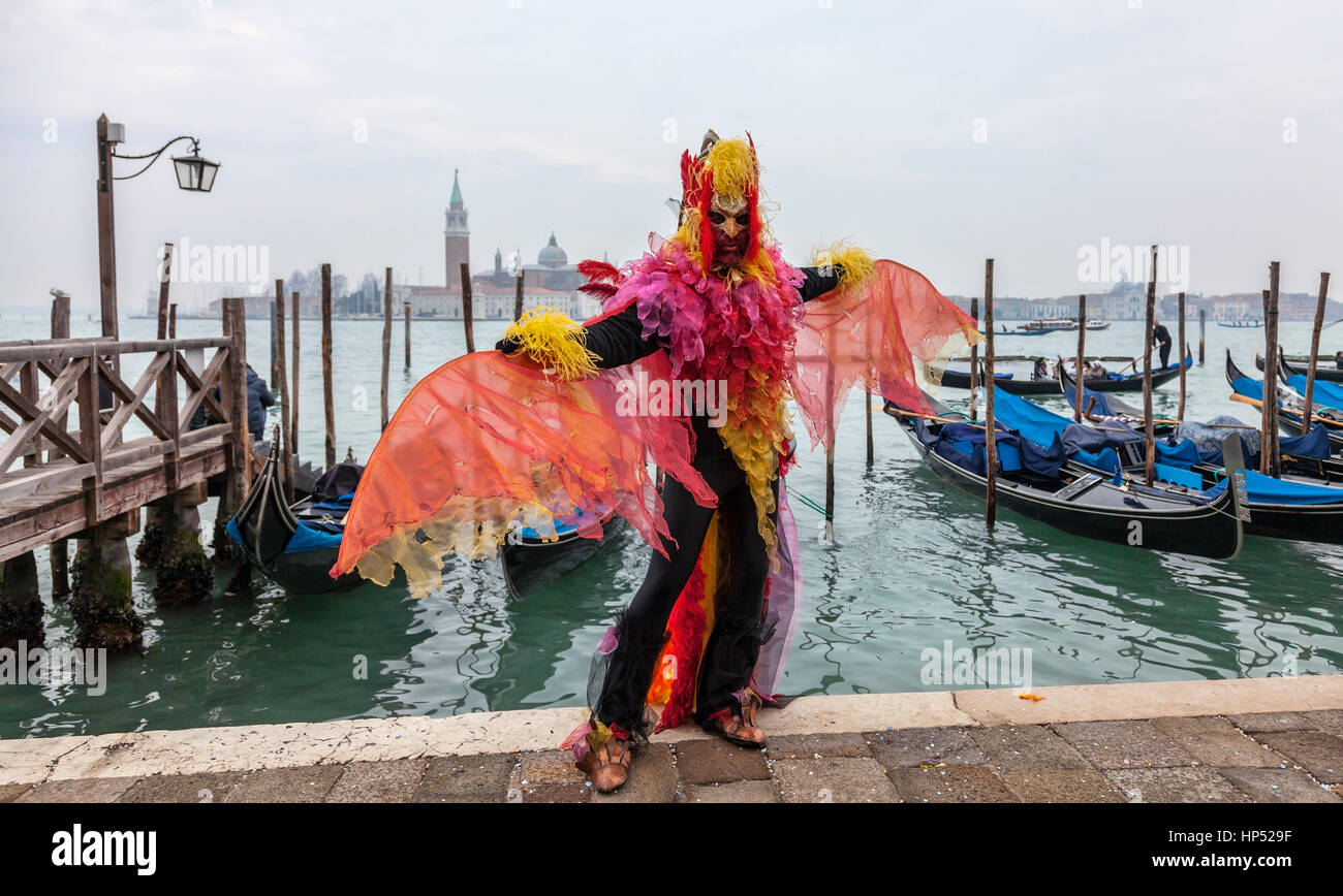 Venedig, Italien - 19. Februar 2012: ein Mann verkleidet in einem bunten Kostüm tanzen vor der Gondel Dock in Venedig während der Karneval-Tage. Stockfoto
