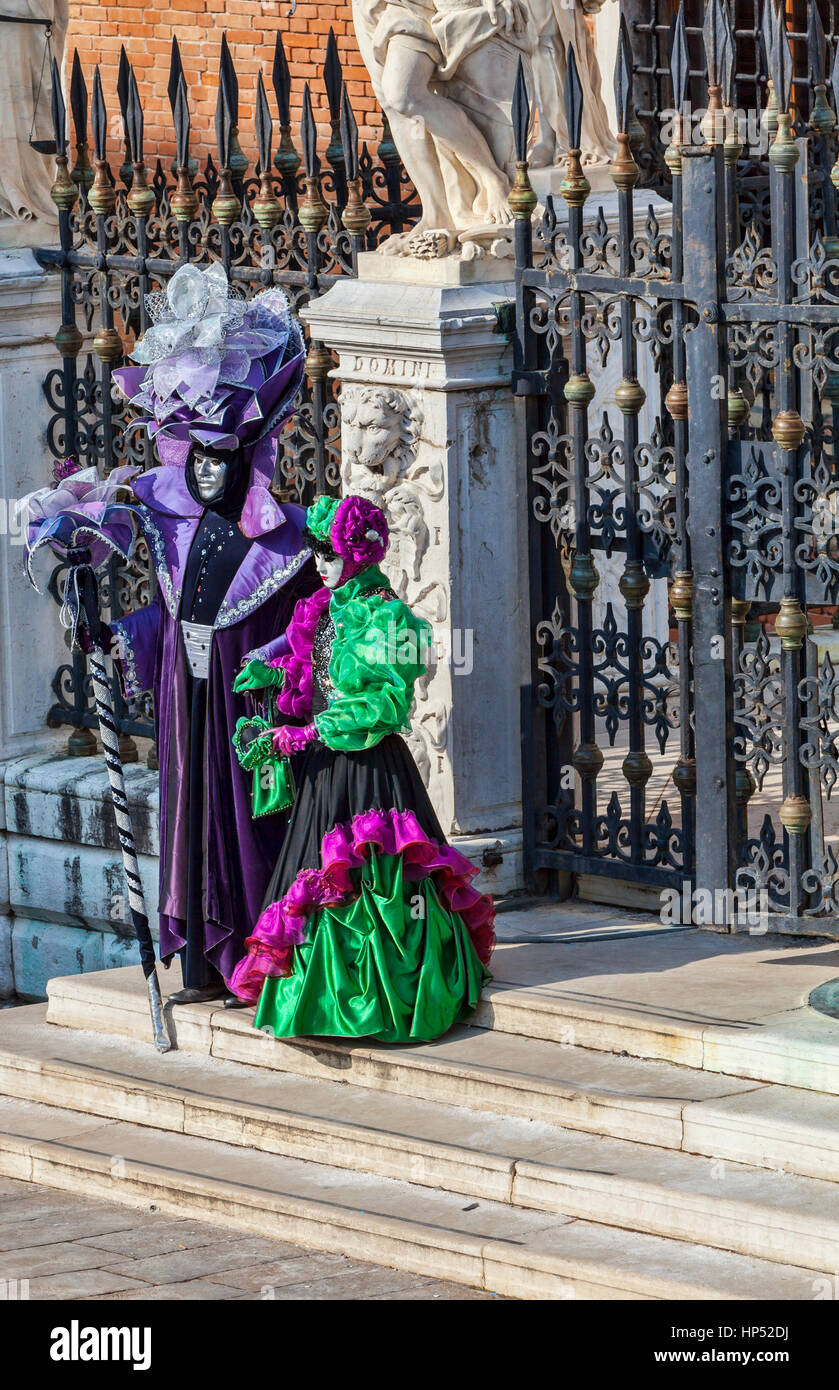 Venedig, Italien - 18. Februar 2012: zwei verkleidete Menschen posieren vor einem traditionellen Gebäude in den Karneval von Venedig-Tagen. Stockfoto