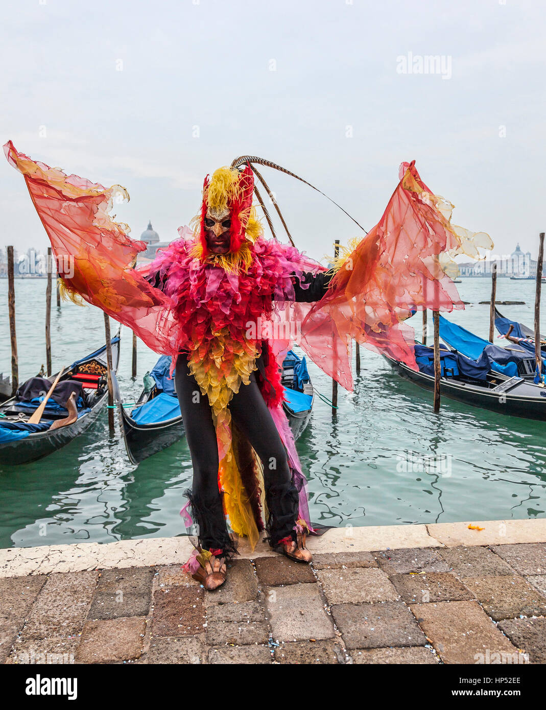Venedig, Italien - 19. Februar 2012: ein Mann verkleidet in einem bunten Kostüm tanzen vor der Gondel Dock in Venedig während der Karneval-Tage. Stockfoto