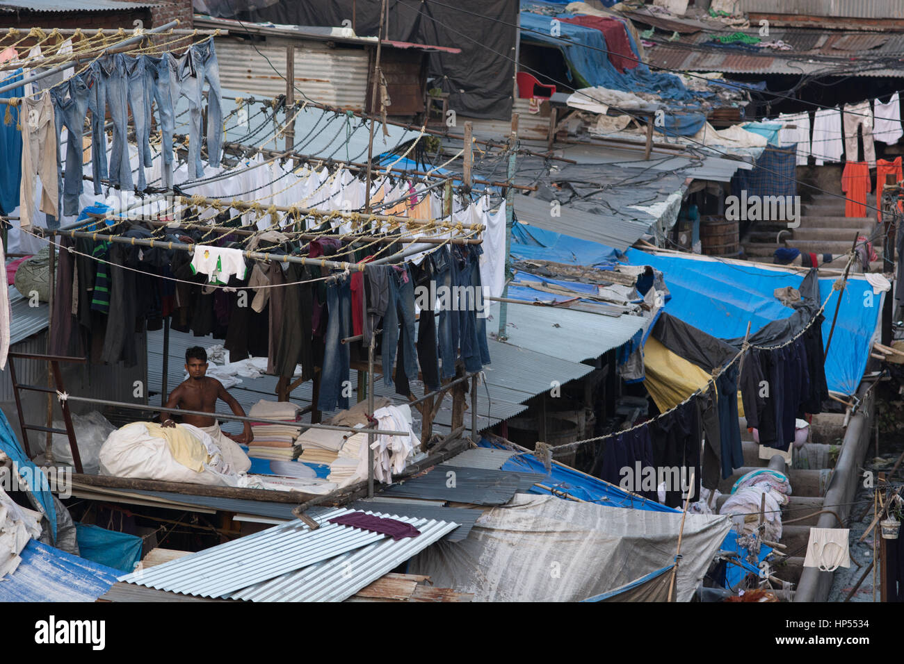 Mumbai, Indien - 11. Dezember 2016 - Muslim waschen vor Ort Dhobi Ghat vor Mumbai Skyline. Mann, die Falten der Kleidung Stockfoto