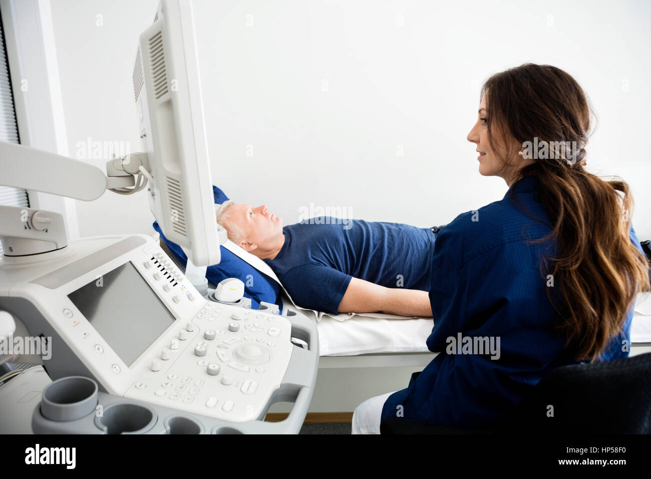 Arzt bei Monitor während der Ultraschalluntersuchung in Hospi Stockfoto