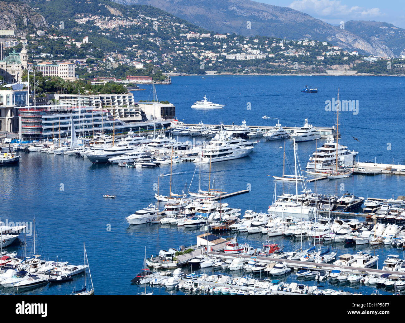 Beschäftigt Monaco Hafen mit Super, Mega-Yachten, Schiffe, Segelboote mit Monte-Carlo im Hintergrund Stockfoto