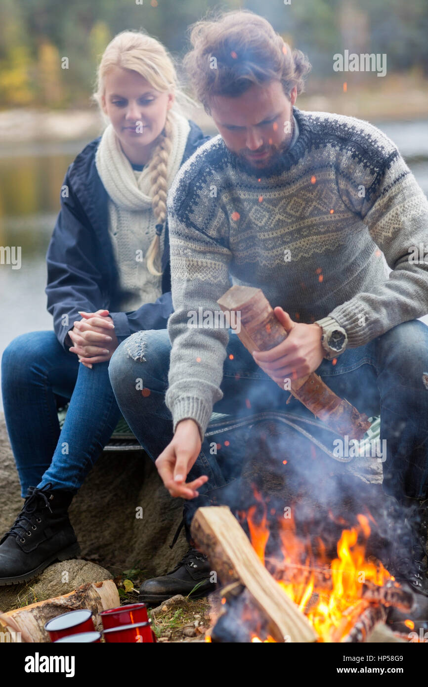 Paar durch Lagerfeuer sitzen auf Lakeshore Stockfoto