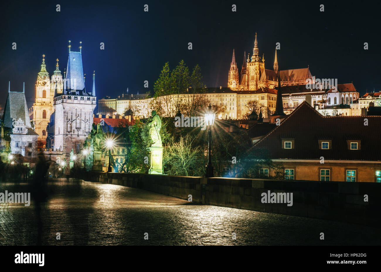 Karlsbrücke mit Statuen und die Prager Burg bei Nacht. Schöne Stadtbeleuchtung. Tschechische Republik Stockfoto