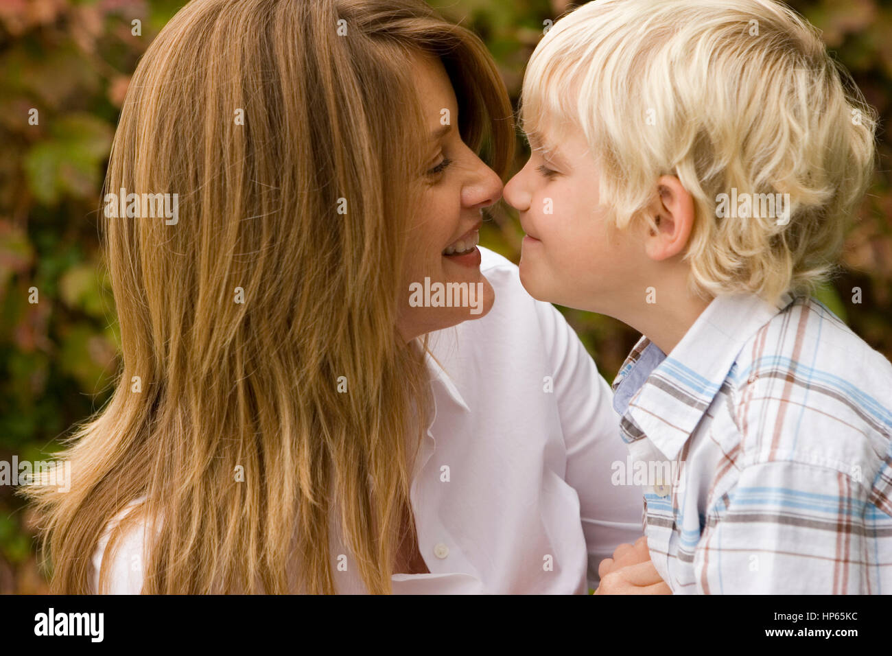Glückliche Mutter umarmt ihren Sohn vor. Stockfoto