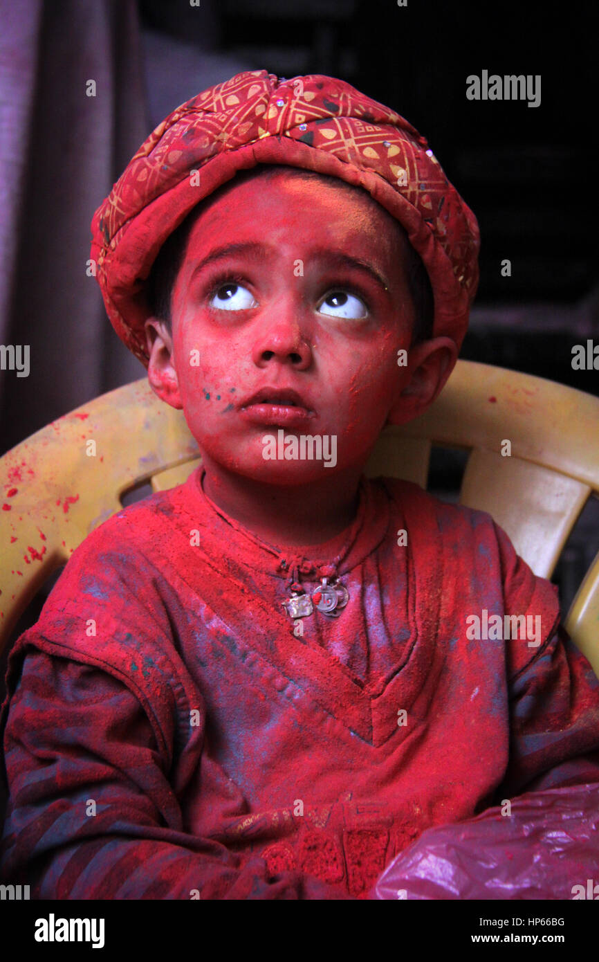 Porträt eines Kindes mit Holi rote Farben während Holi feiern in Vrindavan, Indien abgedeckt Stockfoto